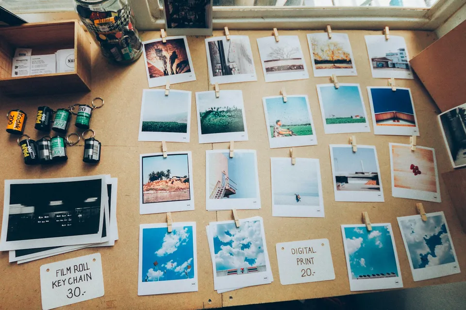 Rows of printed photos pinned up in order on a corkboard